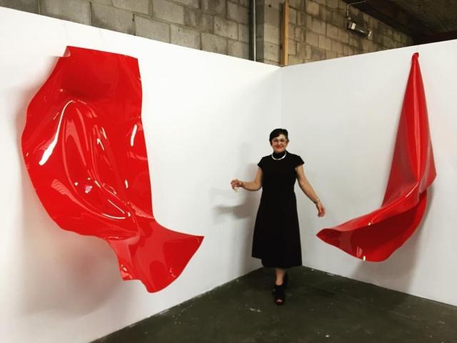 Artist Anya Pesce with her works at Factory 49. Photograph by Jim Gurieff