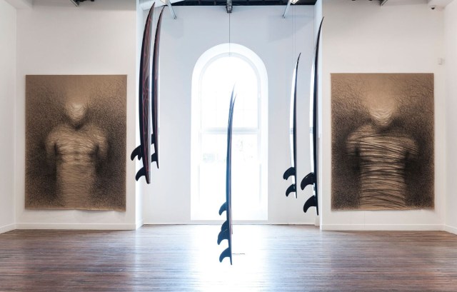 Vernon Ah Kee: not an animal or a plant, installation view at NAS Gallery, L to R Lynching II 2015 charcoal and crayon on linen 300 x 200 cm; Authors of Devastation 2016 digital prints on custom-made surfboards (6 parts) 180 x 40 cm; Lynching I 2015 charcoal and crayon on linen 300 x 200 cm. Photo: Peter Morgan